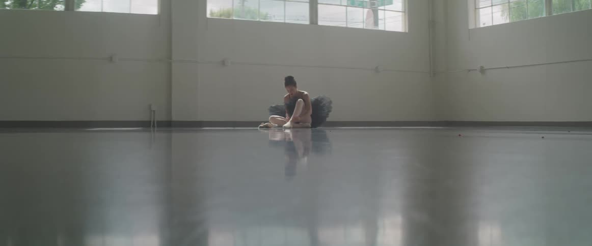 A woman is sitting in the corner putting on shoes