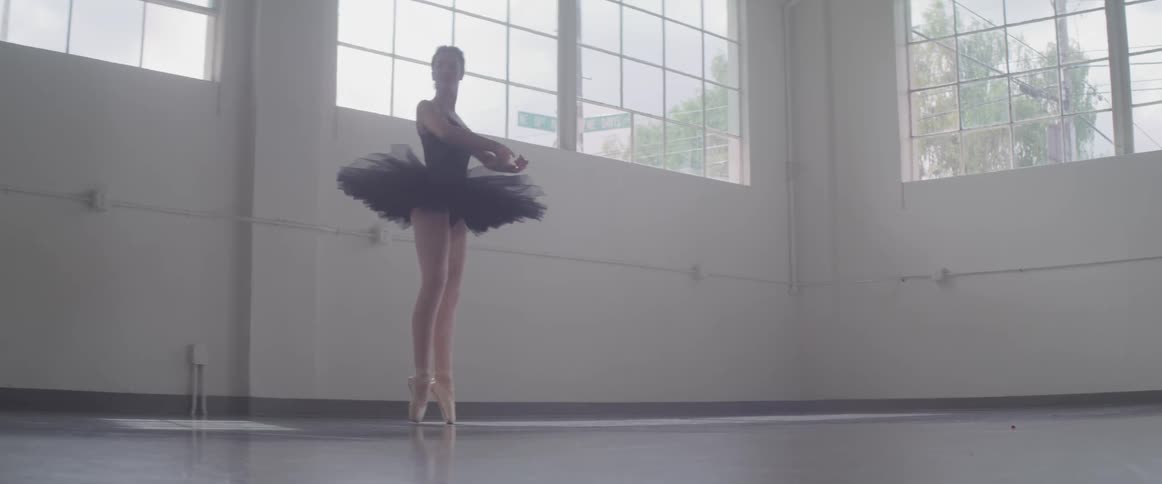 A woman is doing ballet indoors