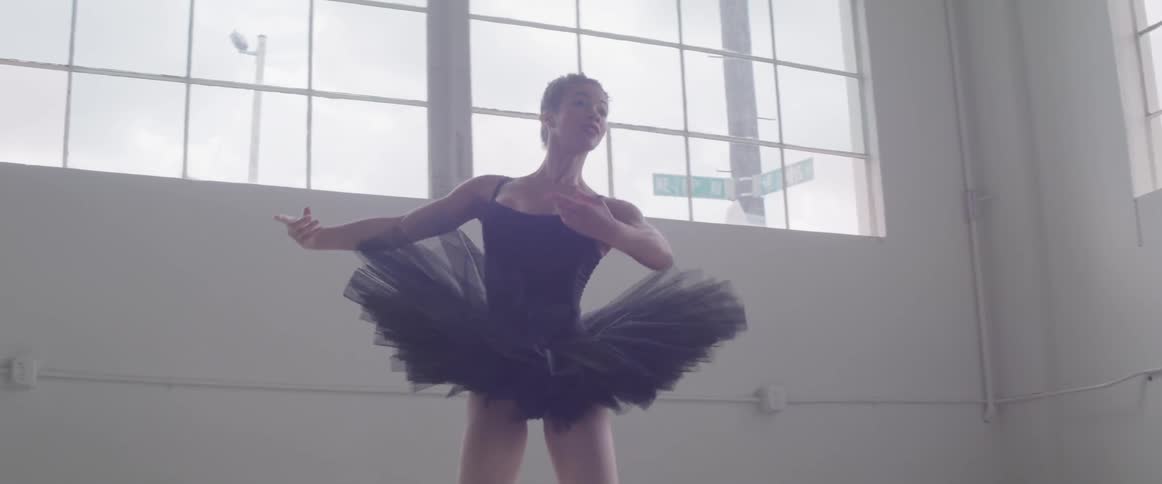 A ballerina dances in a studio