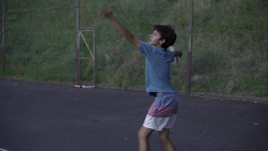 Young Boy Hitting Tennis Ball Outdoors on Sunny Day Outdoor Sports Footage Clip.