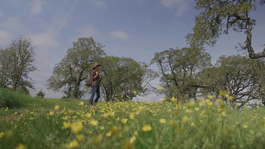 A woman stands in a field of flowers