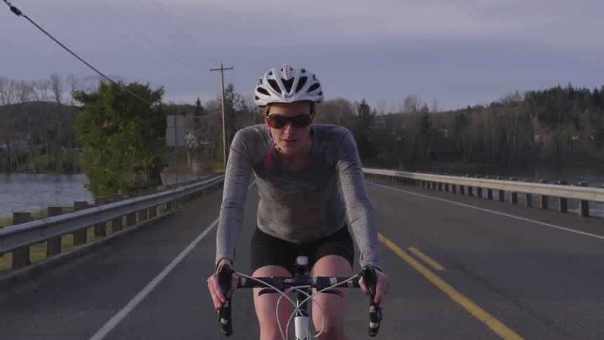 Bicyclists rides along bridge over river