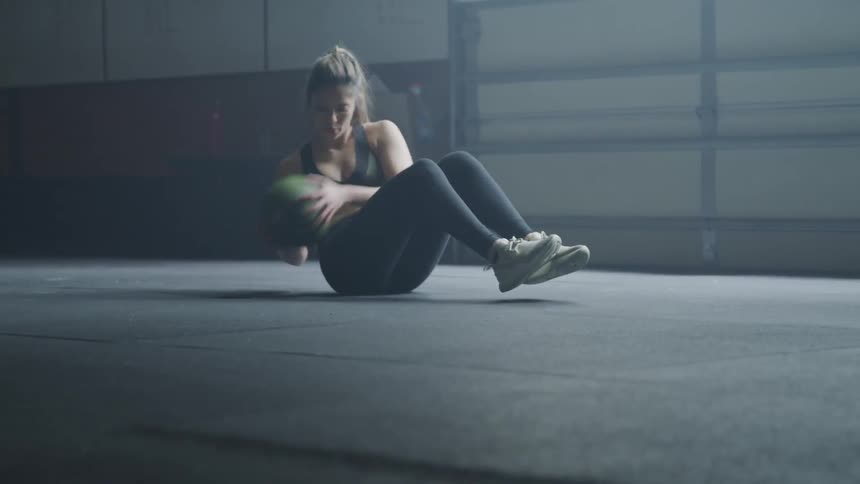 Woman doing exercise with ball at the gym near the window