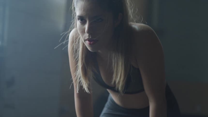 Woman takes a break during workoutin the dim light by day