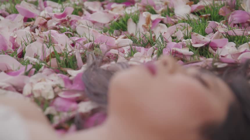 Woman laying down on flowers in grass