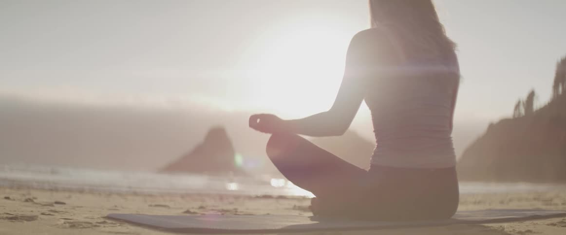 A woman does a mantra at the beach