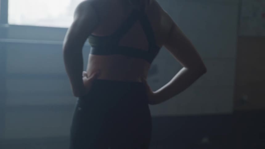 Brunette woman has a break during workout and looks out the window