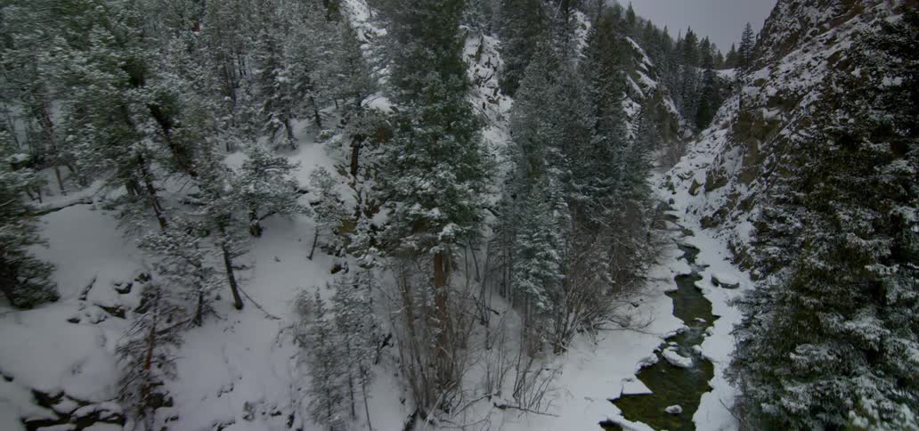 Landscape view of a river covered in snow and the snow covered hills next to it