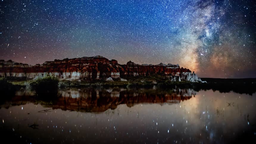 Landscape view of a mountain range and shooting stars and space in the background