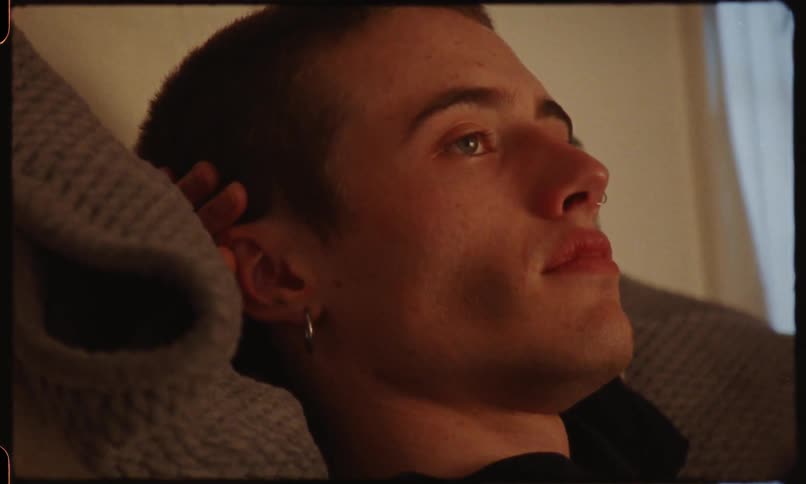 A teenager rests his head in his hand