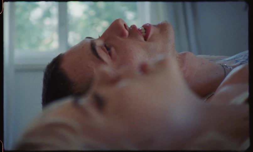 A couple lay supine on a bed in a period house and talk