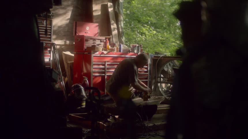 Man using power tool to sand wood on workshop