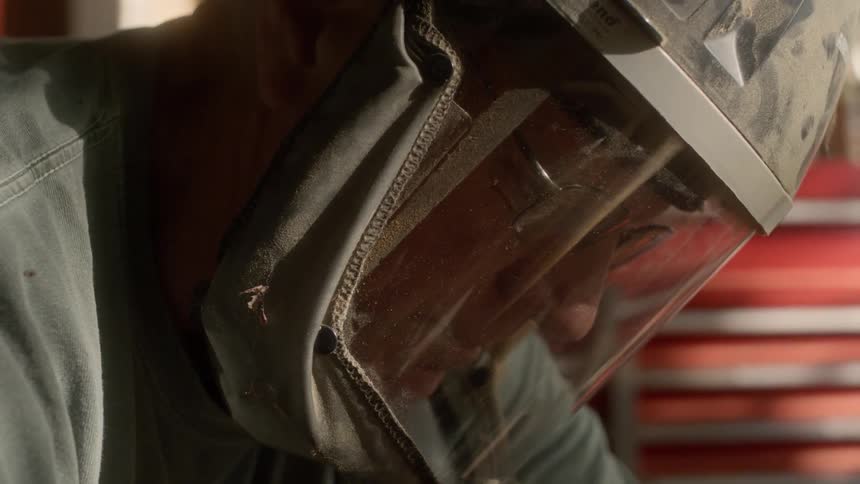 Man wears whole face protective mask as he works