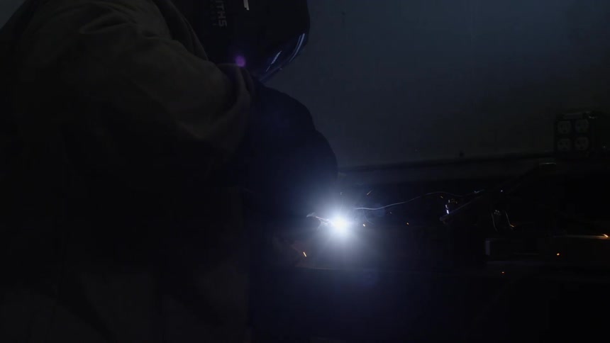 Man welding an object at the workshop room