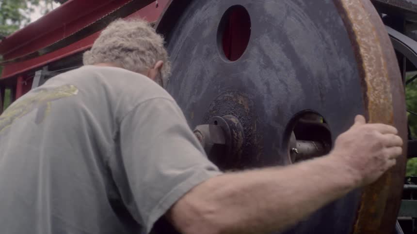 Two people working on a large wheel