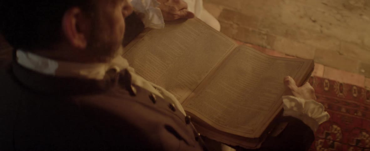 A well dressed elderly man reading old book