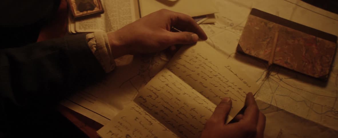 A man writes a letter on parchment
