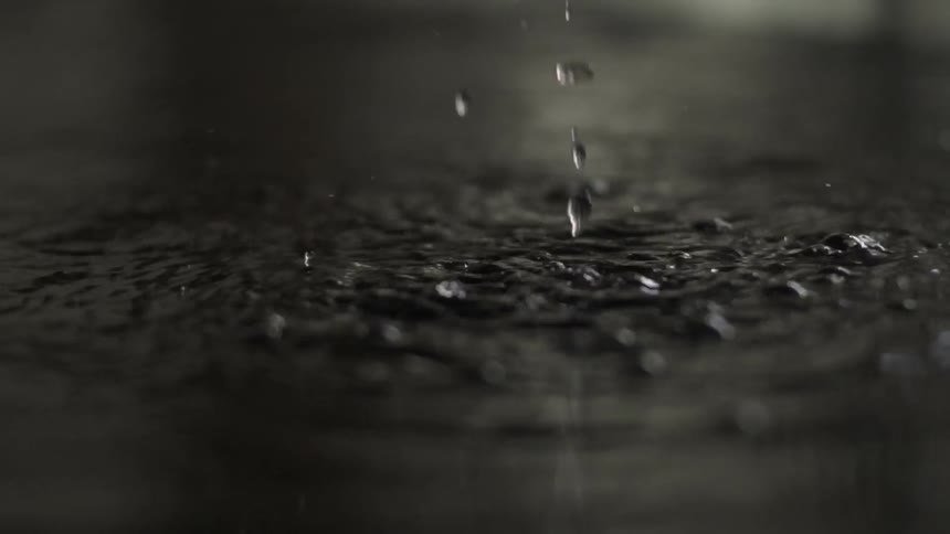 Water Dropping Onto Surface Creating Ripples and Splashes With Natural Fluid Motion.