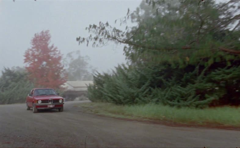 A car drives down a dirt road
