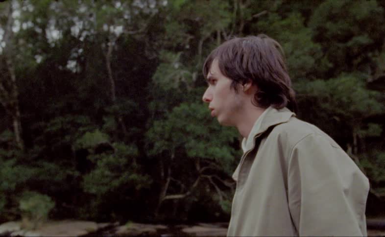 Man stands and looks ahead in the forest during daylight