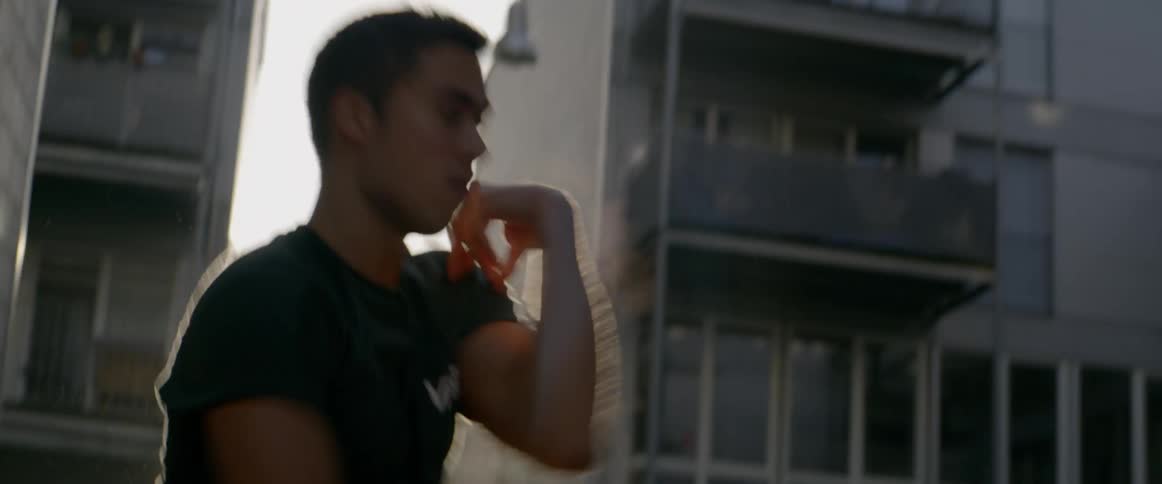 Man dances in the street while the sun shines brightly