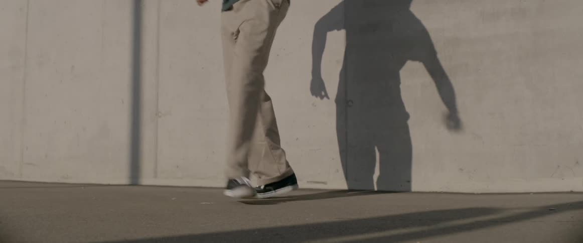 Man dancing outdoors casting shadow on wall