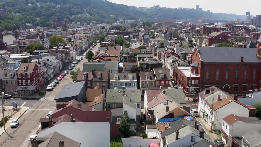 A town near mountains is densely populated with homes and businesses