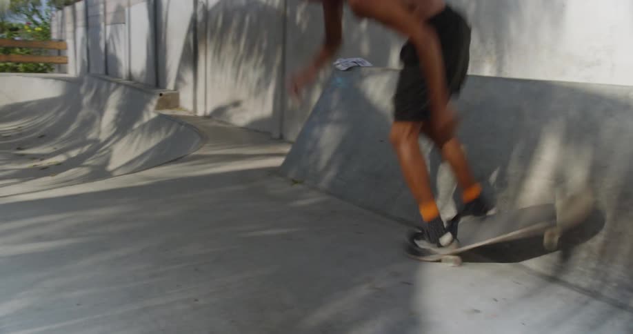 A boy rides a skateboard and falls when attempting a trick