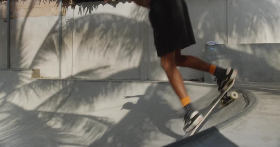 Young male skateboarding in a bowl outdoors