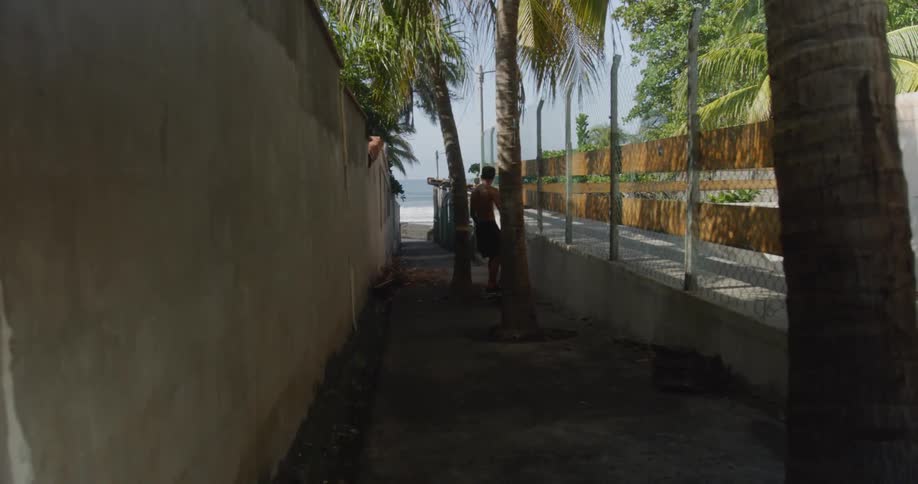 Teenage skateboarding on a pathway to the beach