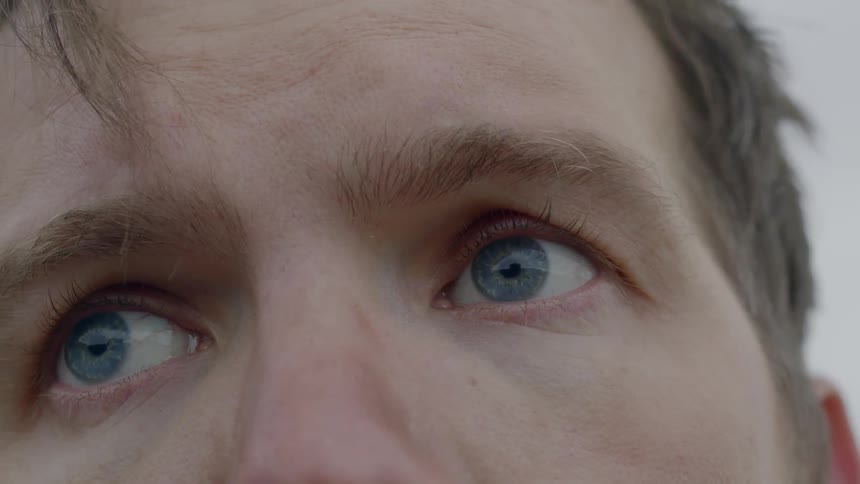 A white man stares into the distance