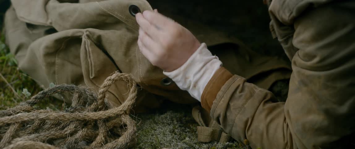A man rifles through a military rucksack for a book on geography