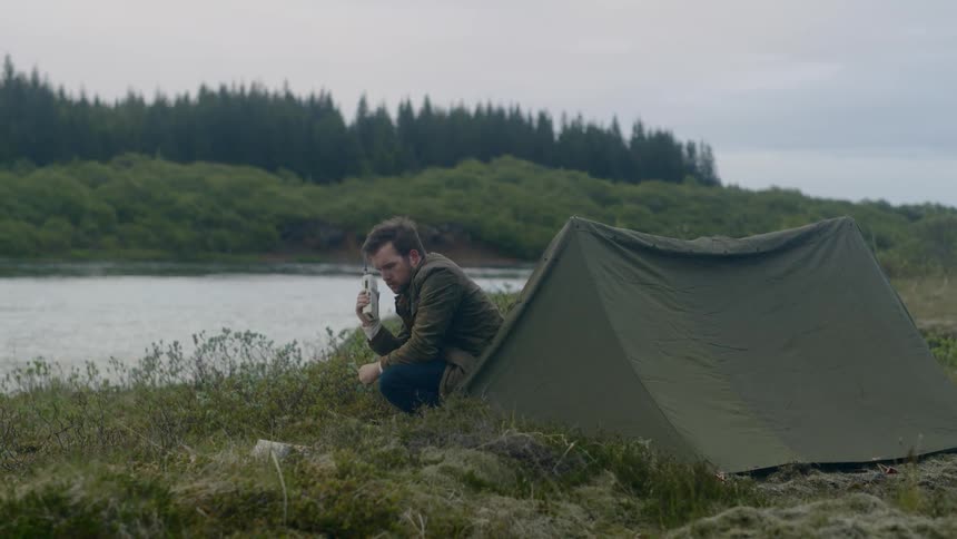 Man checking the walkie talkie on a camp
