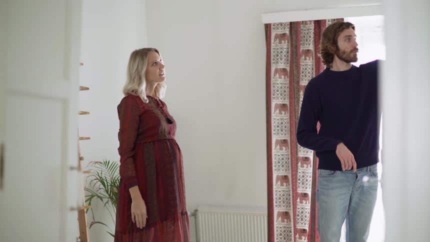 A pregnant white woman gives directions to a white man
