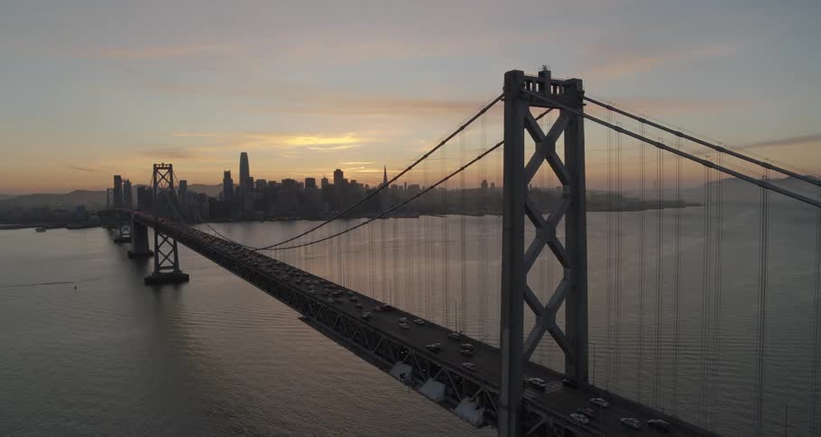 An aerial view of a bridge and metropolitan city at dawn