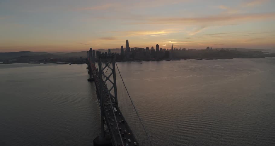 A suspension bridge carrying traffic stretches across a body of water
