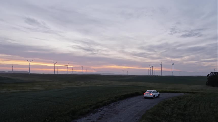 A car is facing windmills