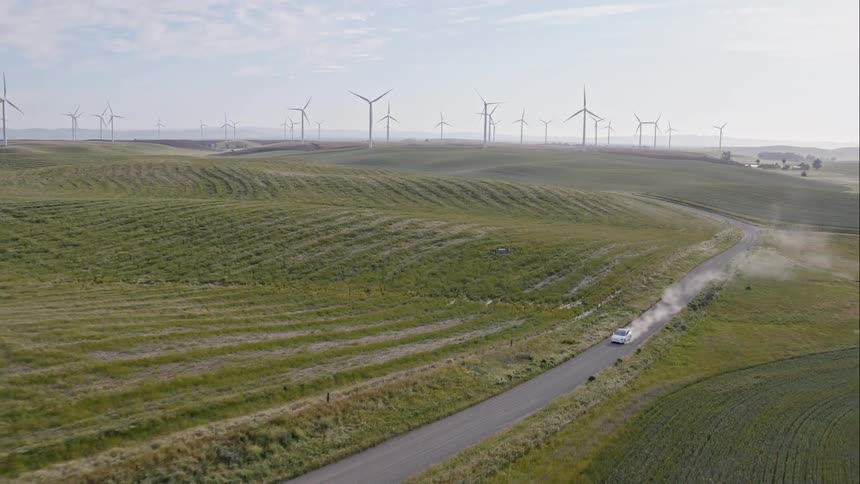 Car driving through a wind farm