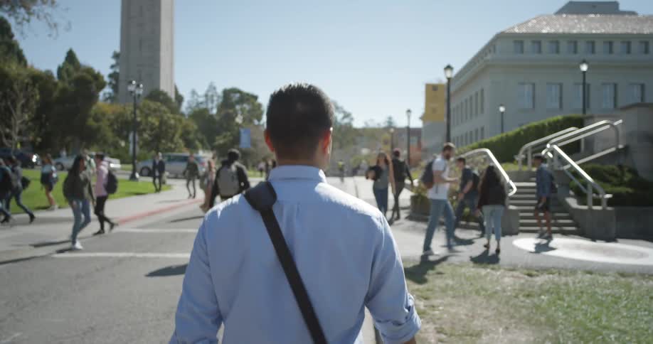 A man walks through a busy campus