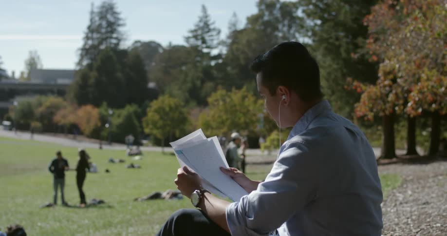 A man is reading papers on the hill