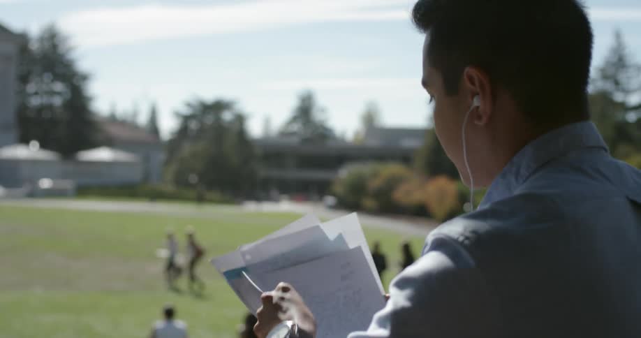A person is looking at papers while sitting outdoors