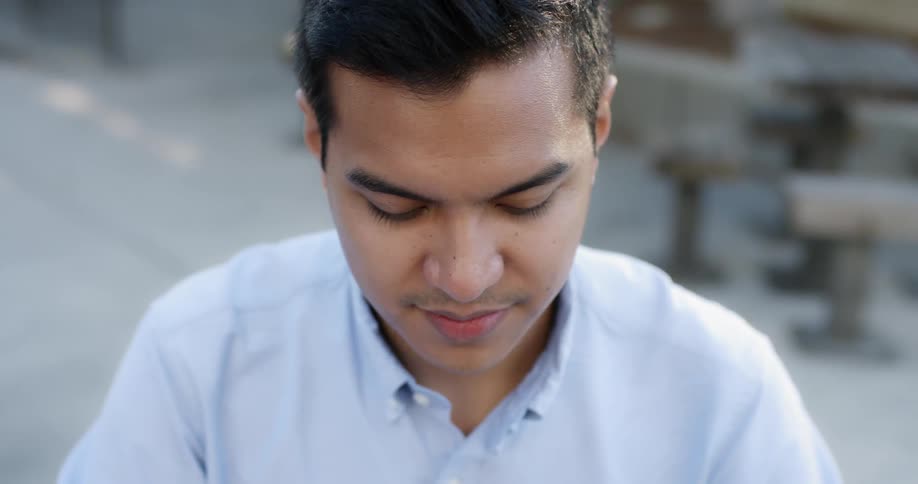 A man outside at daytime looking downwards