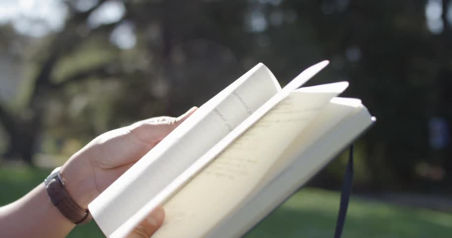 A person wearing earbuds is reading a hand written journal