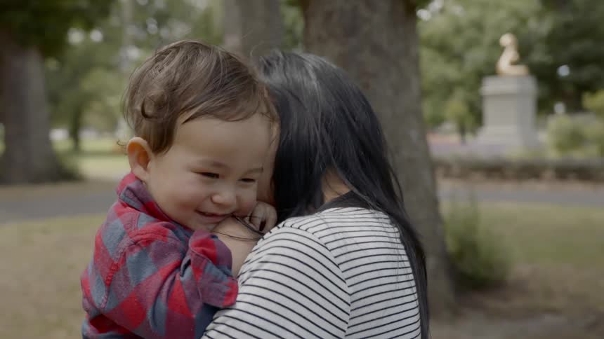 A mother kissing her baby son on his face