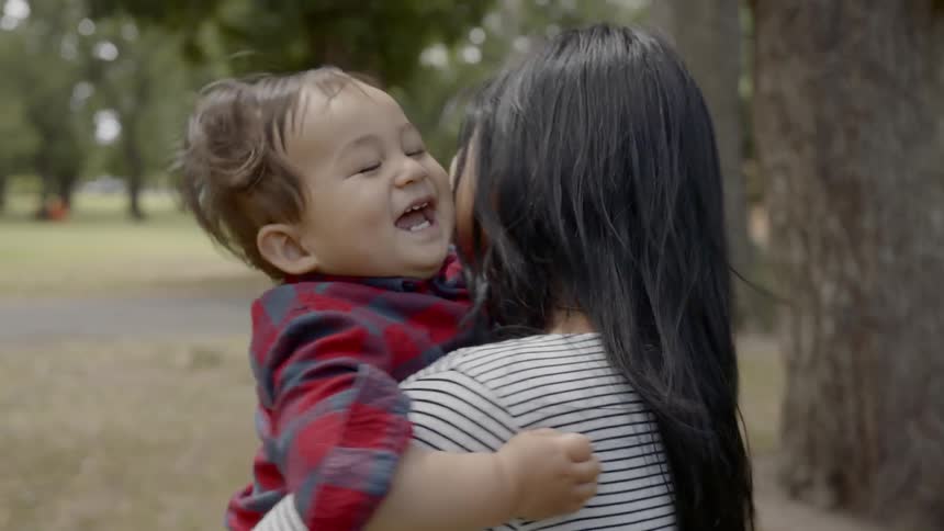 Mother holding baby outdoors on park