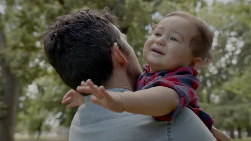 Father is holding his son outdoors