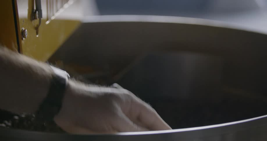 A white man runs coffee beans through his hand