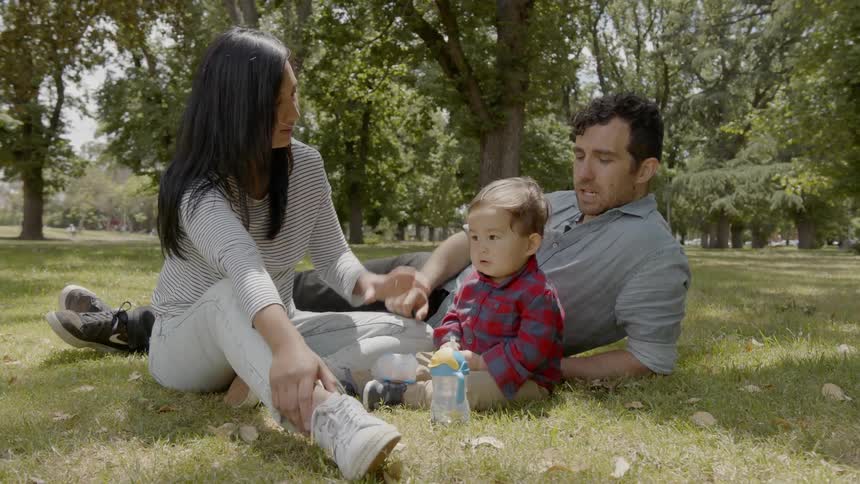 Family with a new born hanging out at the park