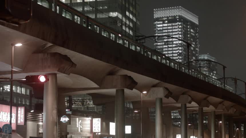 Two electric trains pass each other at night in lit city