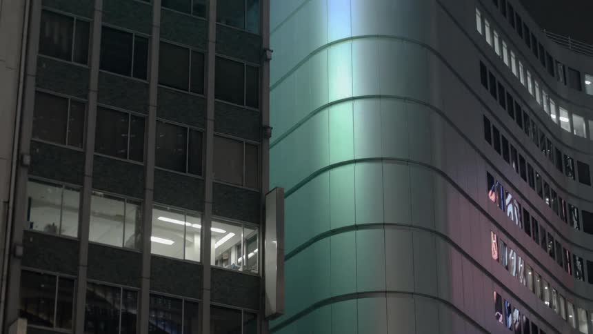 Lights shine from windows on a skyscraper at night